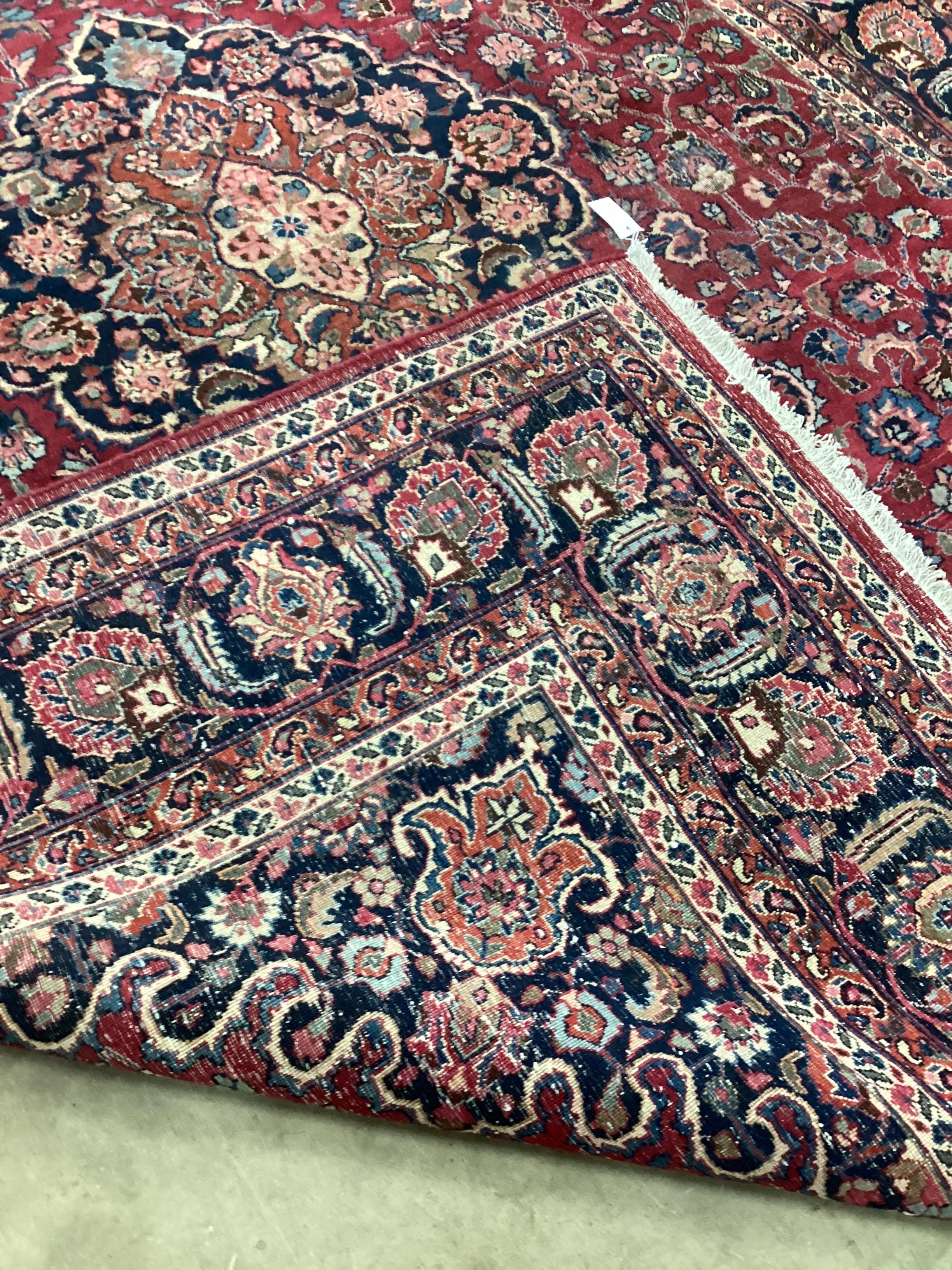 A Tabriz burgundy ground floral carpet 334 x 224cm